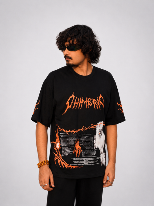Front view of model wearing TNGS black oversized t-shirt with orange Chimeric metal logo and occult graphic.
