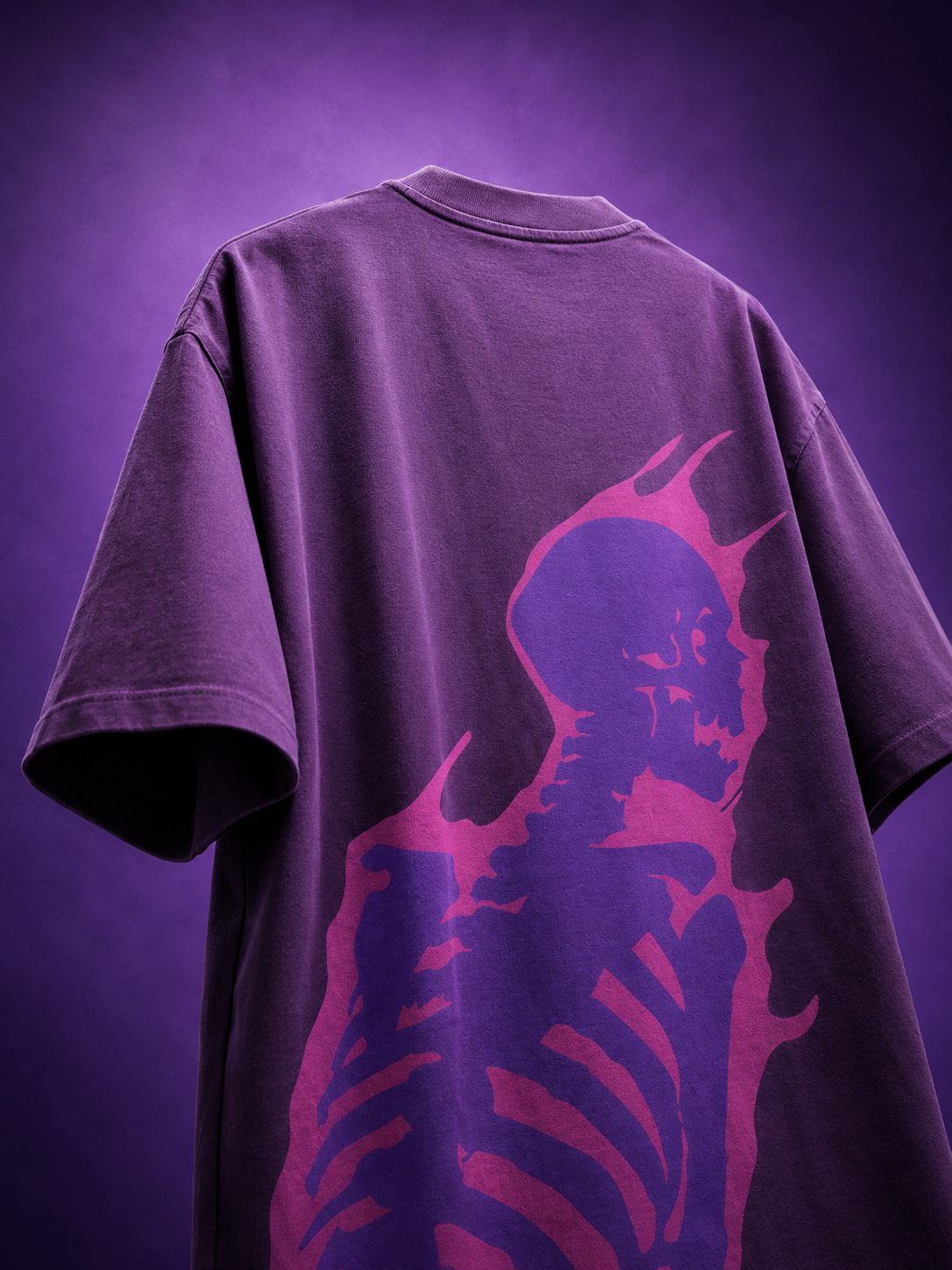 Back angle view of purple oversized streetwear t-shirt featuring vibrant purple flaming skeleton skull graphic print.